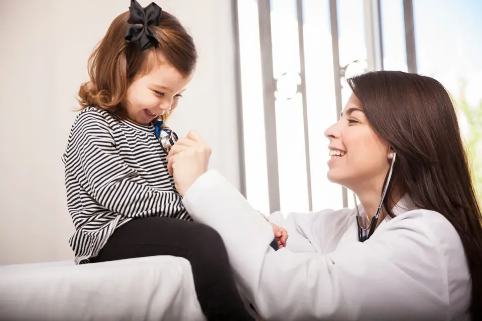 Nurse Practitioner Smiling with Pediatric Patient While Reading Heart Rate